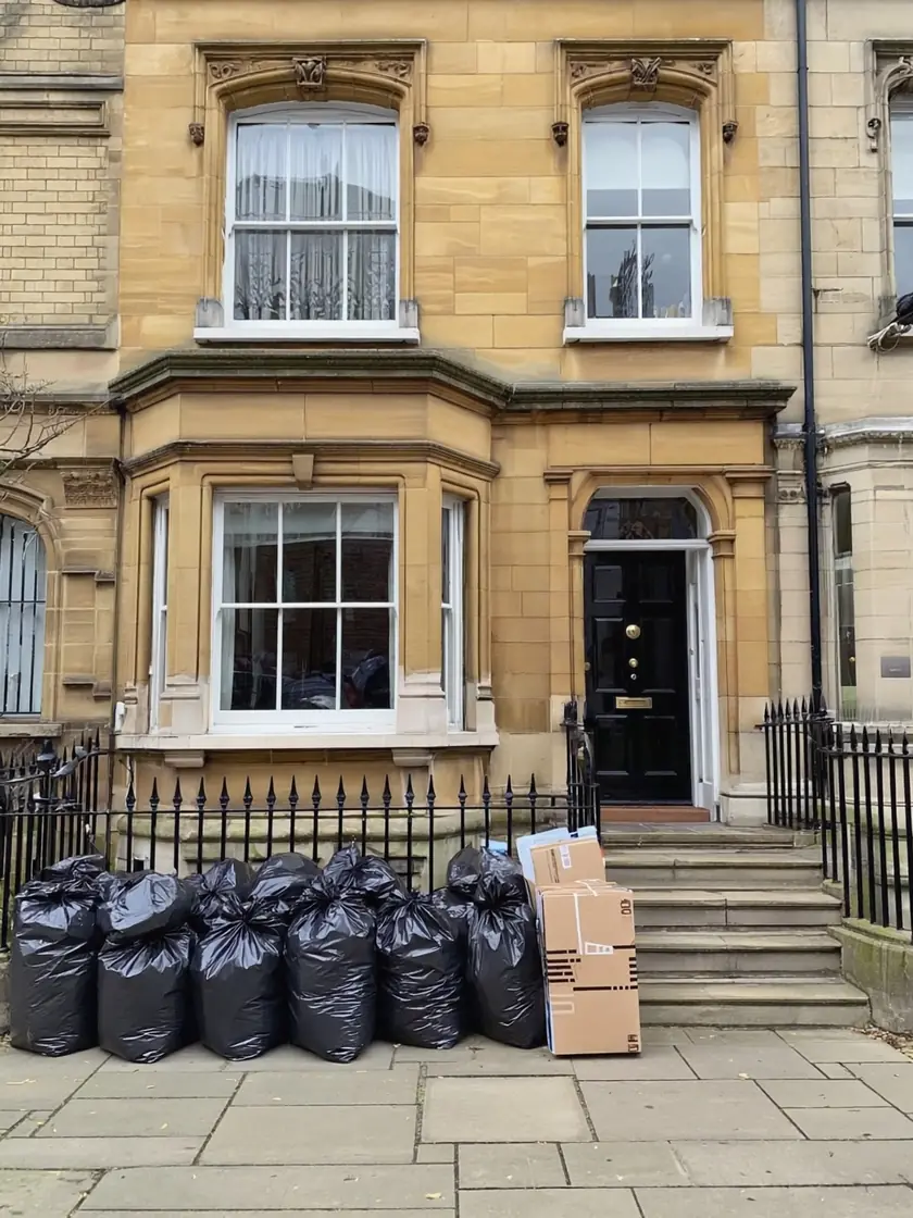 Van being loaded with cleared waste outside a Bradford home